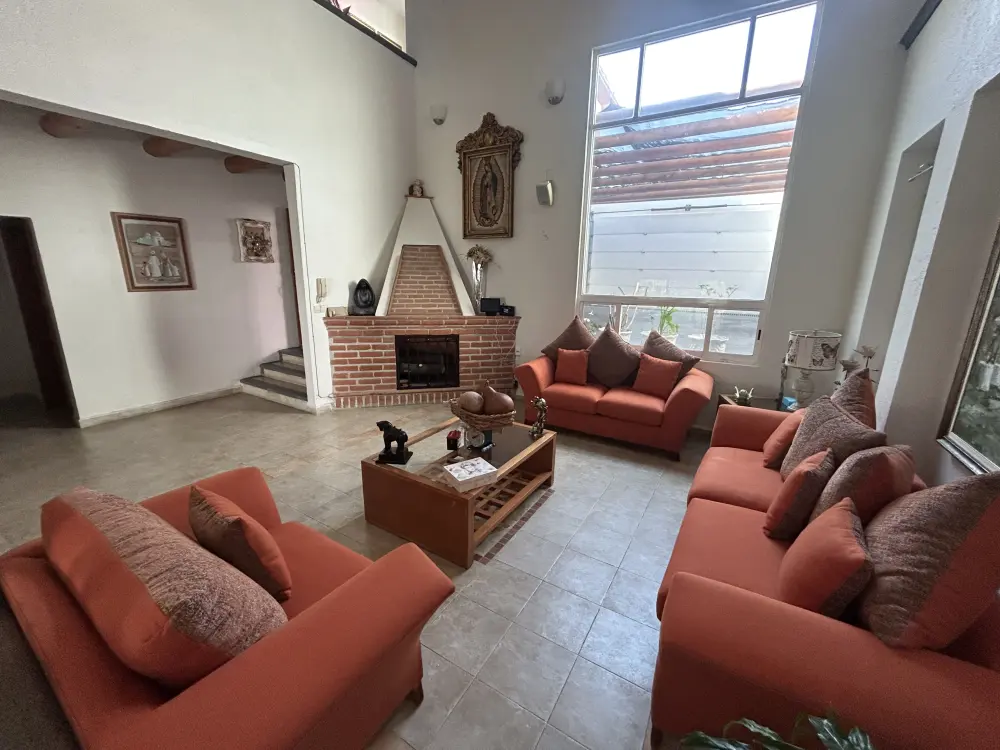 Sala amplia con chimenea de ladrillo en Casa Pinos, Cuernavaca